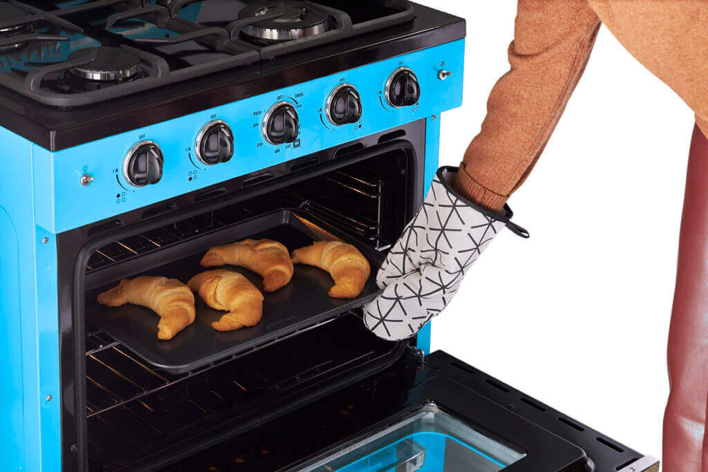 Baking croissants in a blue Unique 30-inch Classic Retro Convection Gas Range from Cabin Depot with oven mitt.