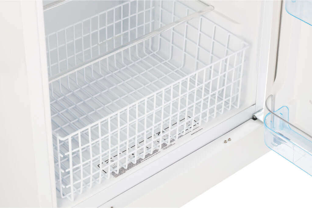 Close-up of the Unique 14 Cu/Ft Propane Fridge freezer compartment available at Cabin Depot, showing adjustable storage basket.